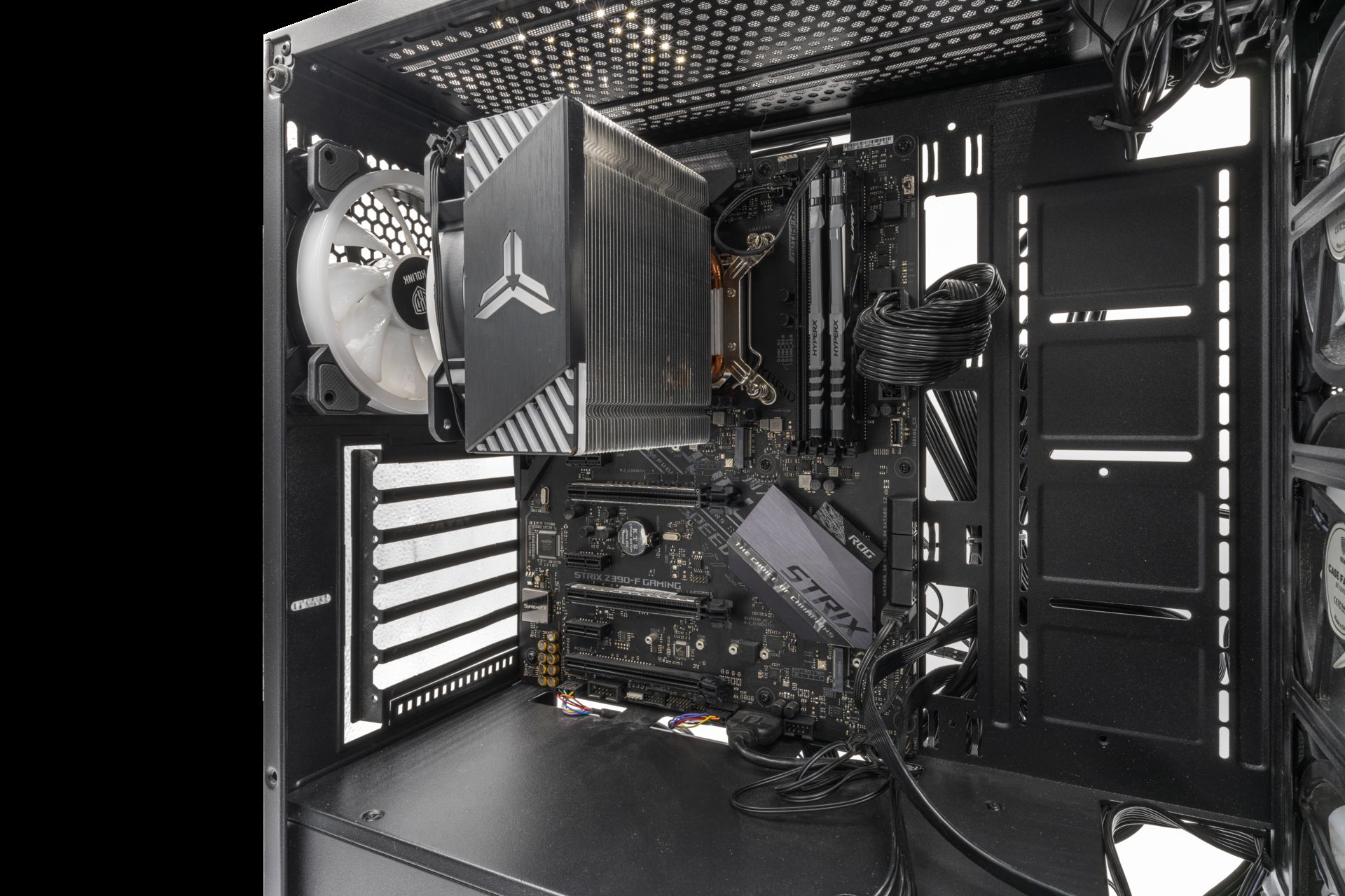 The inside of a black gaming PC: cooler, memory and graphics card slots, lit in white
